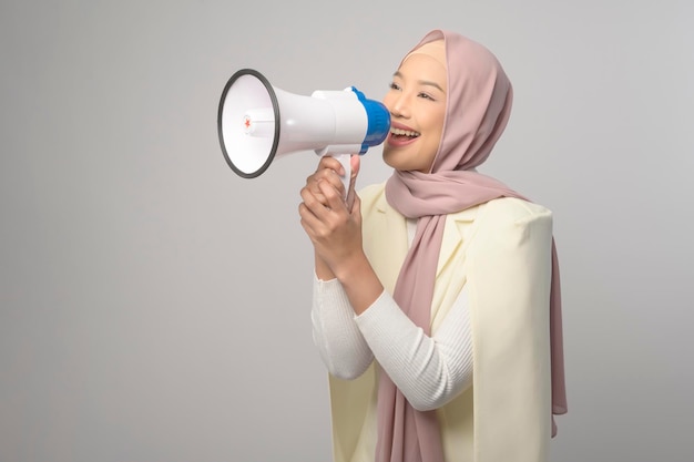 Young beautiful woman holding megaphone over white background studiox9