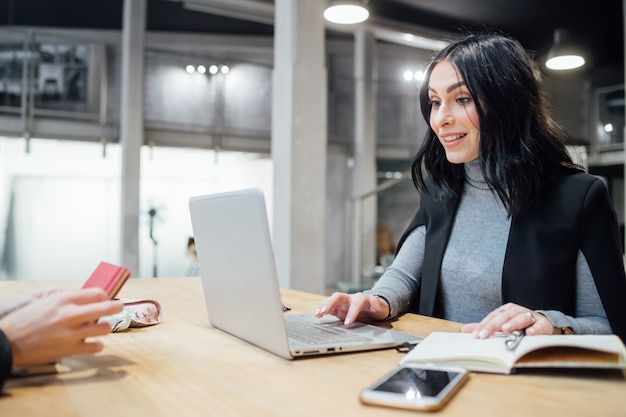 Young beautiful woman indoor using computer sitting working desk