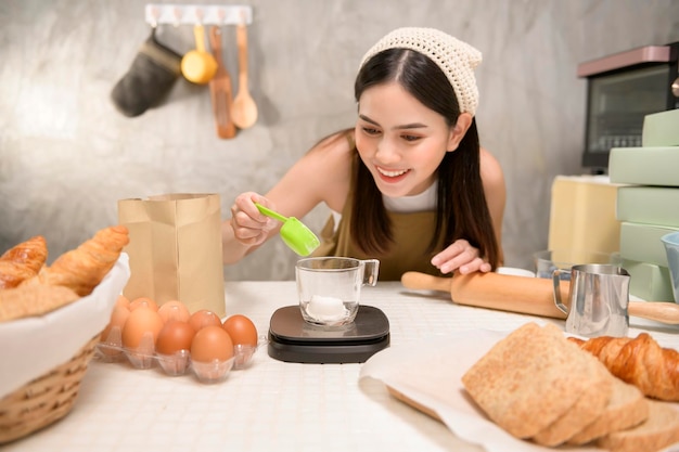 Young beautiful woman is baking in her kitchen bakery and coffee shop business