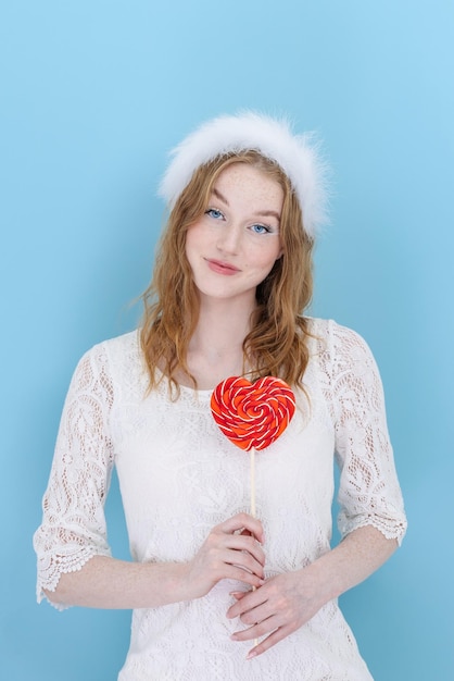 Young beautiful woman is holding a heart shaped candy