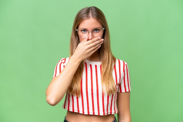 Young beautiful woman over isolated background covering mouth with hand