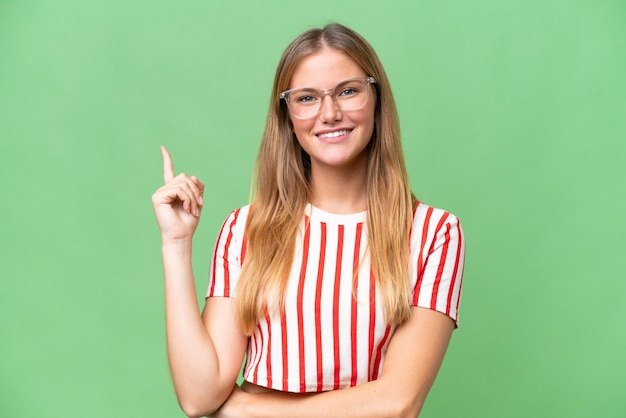 Young beautiful woman over isolated background happy and pointing up