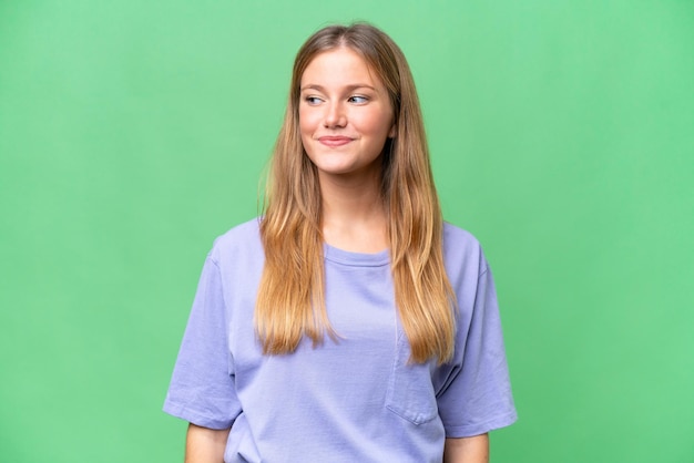 Young beautiful woman over isolated background having doubts while looking side