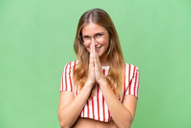 Young beautiful woman over isolated background keeps palm together Person asks for something