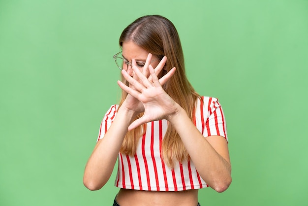 Young beautiful woman over isolated background nervous stretching hands to the front