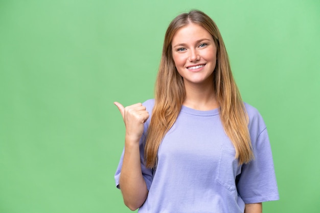 Young beautiful woman over isolated background pointing to the side to present a product