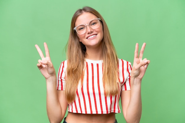 Young beautiful woman over isolated background showing victory sign with both hands