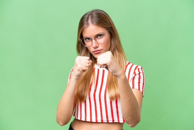 Young beautiful woman over isolated background with fighting gesture