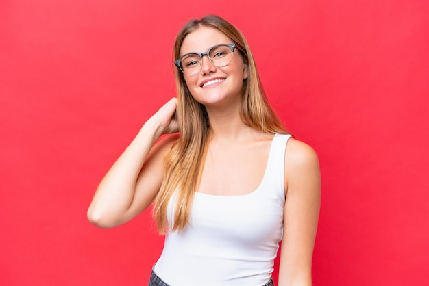 Young beautiful woman isolated on red background laughing