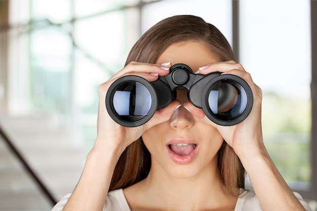 Young beautiful woman looking throung  binoculars