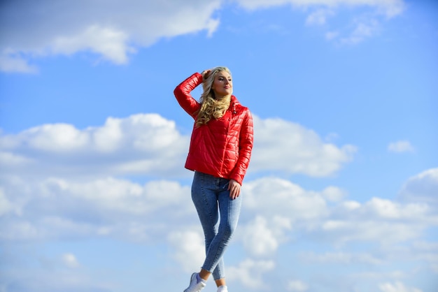 Young and beautiful woman in model pose outdoors feel free woman enjoying weather outdoors Freedom and expectation Beauty and fashion look concept of loneliness woman on blue sky background