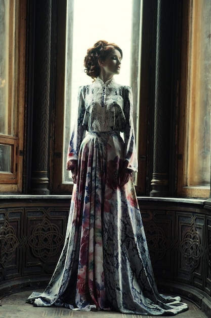 young beautiful woman in pink dress posing in luxury palace