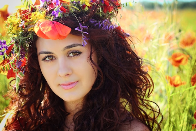 Young beautiful woman in the poppy field