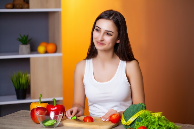 Young beautiful woman prepares a useful diet salad