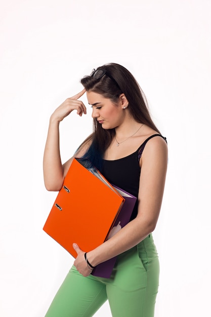 Young beautiful woman reading documents, on white wall.