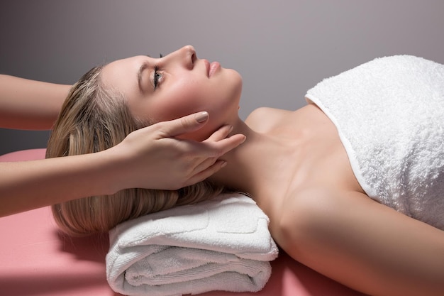 Young beautiful woman receiving facial massage and spa treatment