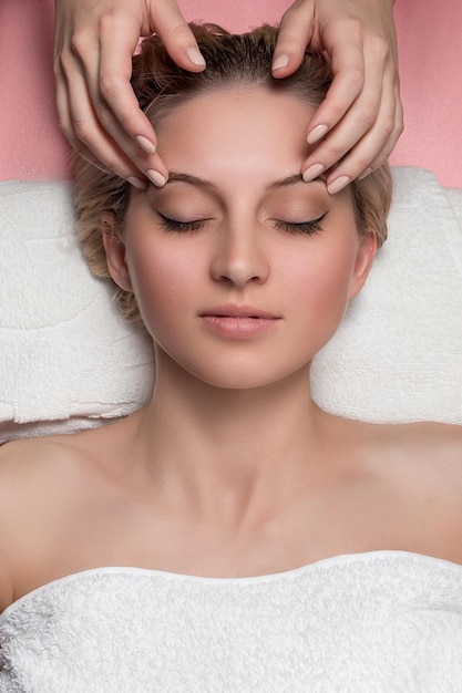 Young beautiful woman receiving facial massage and spa treatment