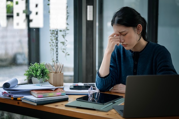 Young beautiful woman sitting at office suffering from headache desperate and stressed because pain and migraine Hands touching her nose