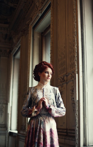 Young beautiful woman standing in the palace room