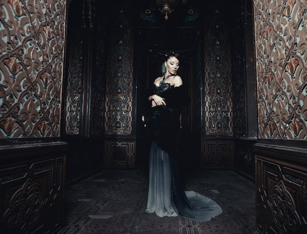 Young beautiful woman standing in the palace room