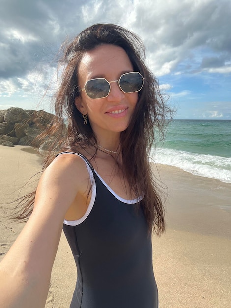 Young beautiful woman taking selfie on the beach