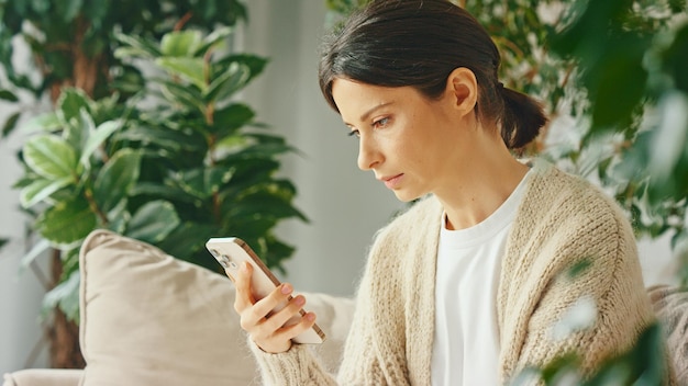 Young beautiful woman typing message using smartphone