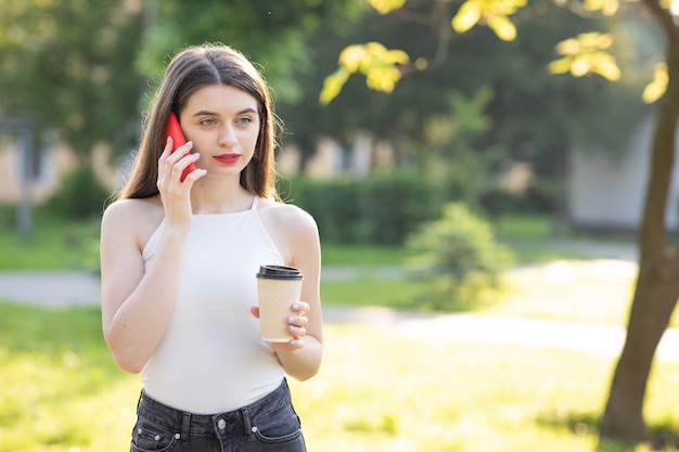 Young beautiful woman using the phone in the park