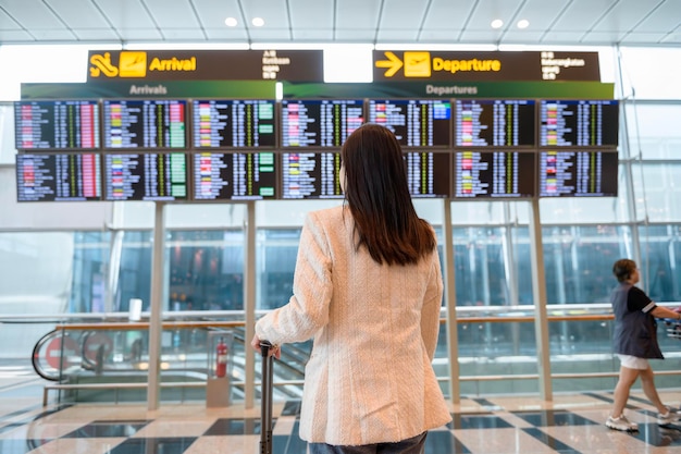 A young beautiful woman walking with suitcase check in at International airport