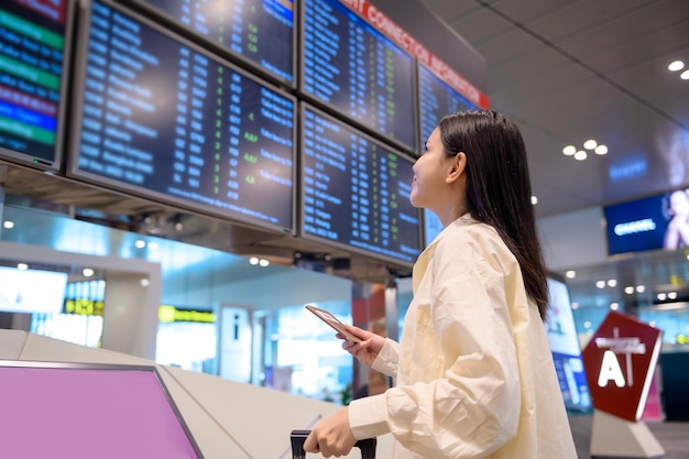 A young beautiful woman walking with suitcase check in at International airport