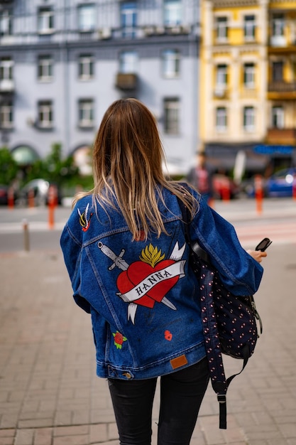 Young beautiful woman walks around the city in Europe, street photo, female posing in the city center