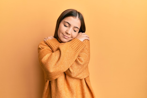 Photo young beautiful woman wearing turtleneck sweater hugging oneself happy and positive smiling confident self love and self care