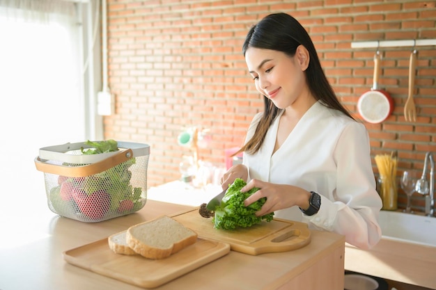 Young beautiful woman in white shirt cooking in the kitchen