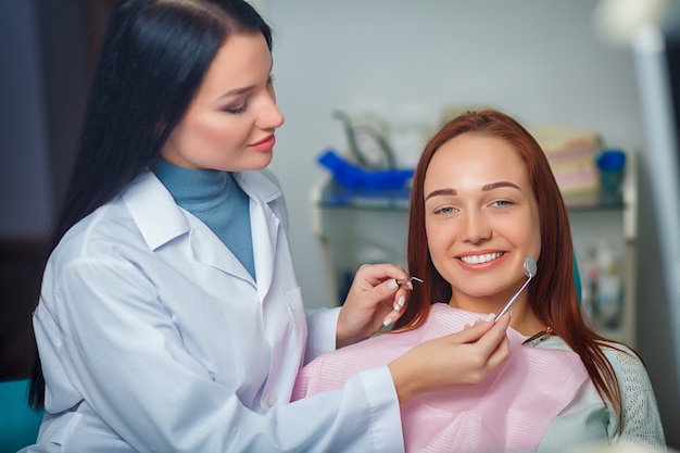 Young beautiful woman with beautiful white teeth sitting on a dental chair. 