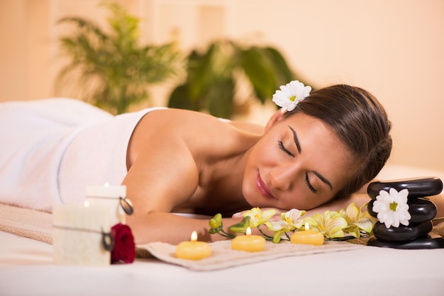 Young beautiful woman with Closed Eyes relaxing and enjoying at the spa center.