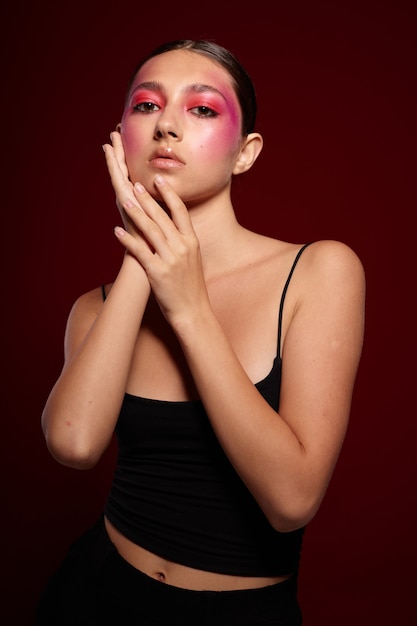 Young beautiful woman with creative makeup on her face posing on background in studio