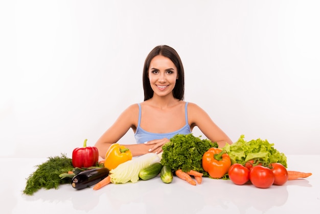 Young beautiful woman with lots of fresh vegetables