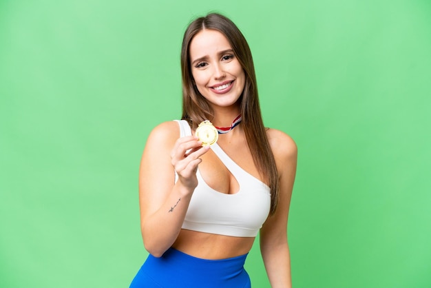 Young beautiful woman with medals over isolated chroma key background with happy expression