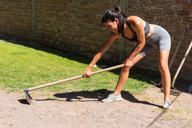 Young and beautiful woman working on the land skinny muscular hardworking working woman