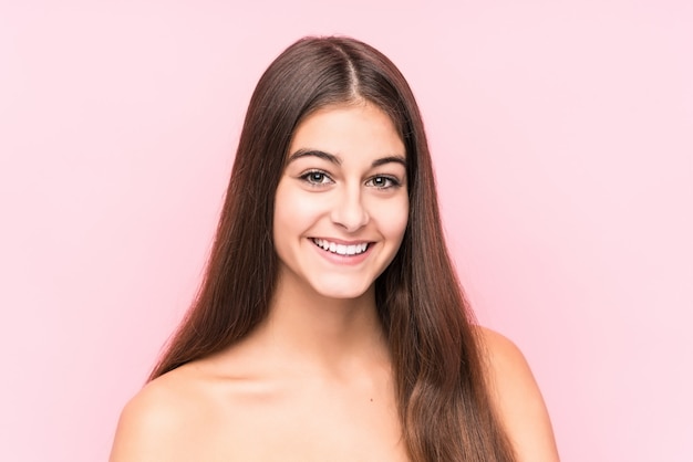 Young beauty caucasian woman against a pink wall