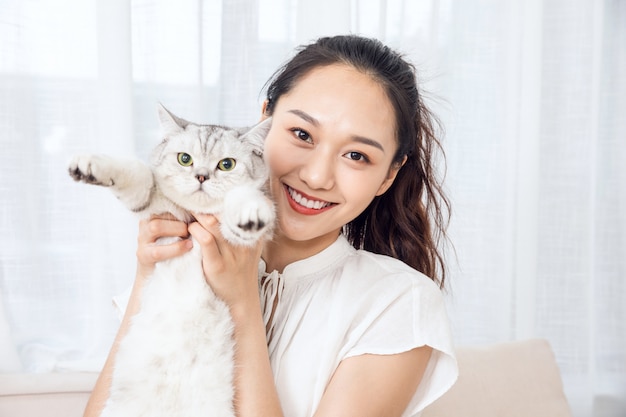 Young beauty licking cat at home