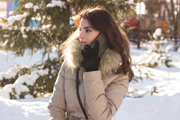 Young beauty woman in winter park in winter cold day