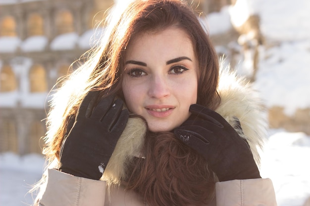 Young beauty woman in winter park in winter cold day