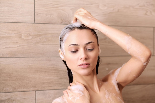 Young beautyful woman under shower in bathroom