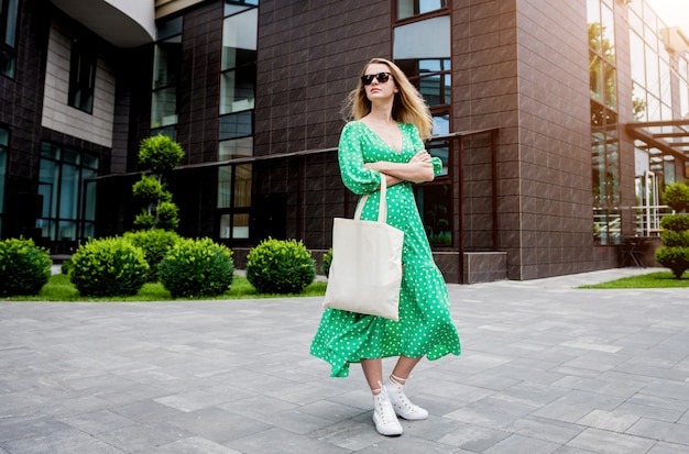 Young beautyful woman with linen eco bag on city background