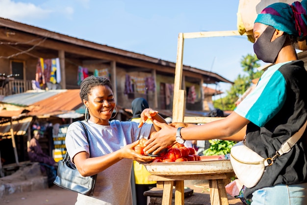 Young black african female businesswoman wearing face mask shopping on a local african market