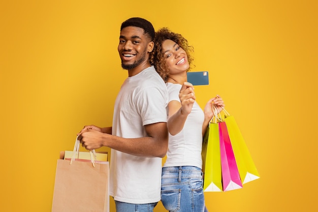 Young black couple with shopping bags and credit card