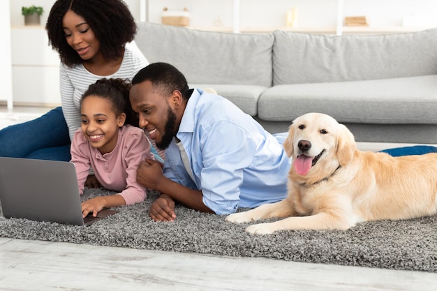 Young black family with dog using laptop