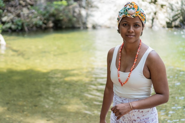 Young black girl with turban in the middle of the river