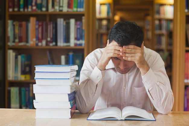 Young black haired man reading a book