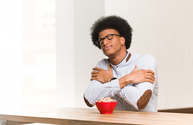 Young black man having a breakfast giving a hug